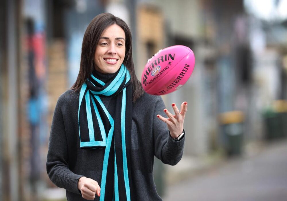 Holly Ransom, global leadership speaker & Port Adelaide football club director tossing an Australian football