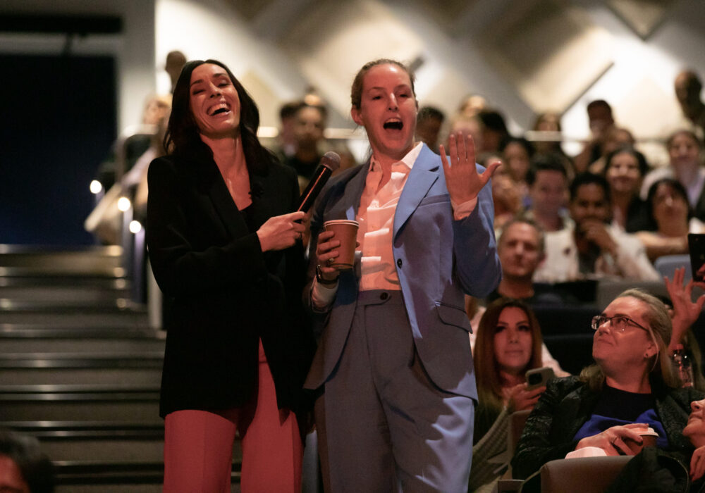 Holly Ransom, global leadership speaker, laughing with an audience member at a conference