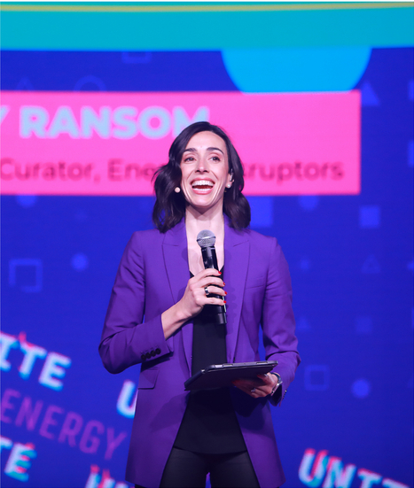 Holly Ransom on stage delivering a powerful message in a purple blazer.