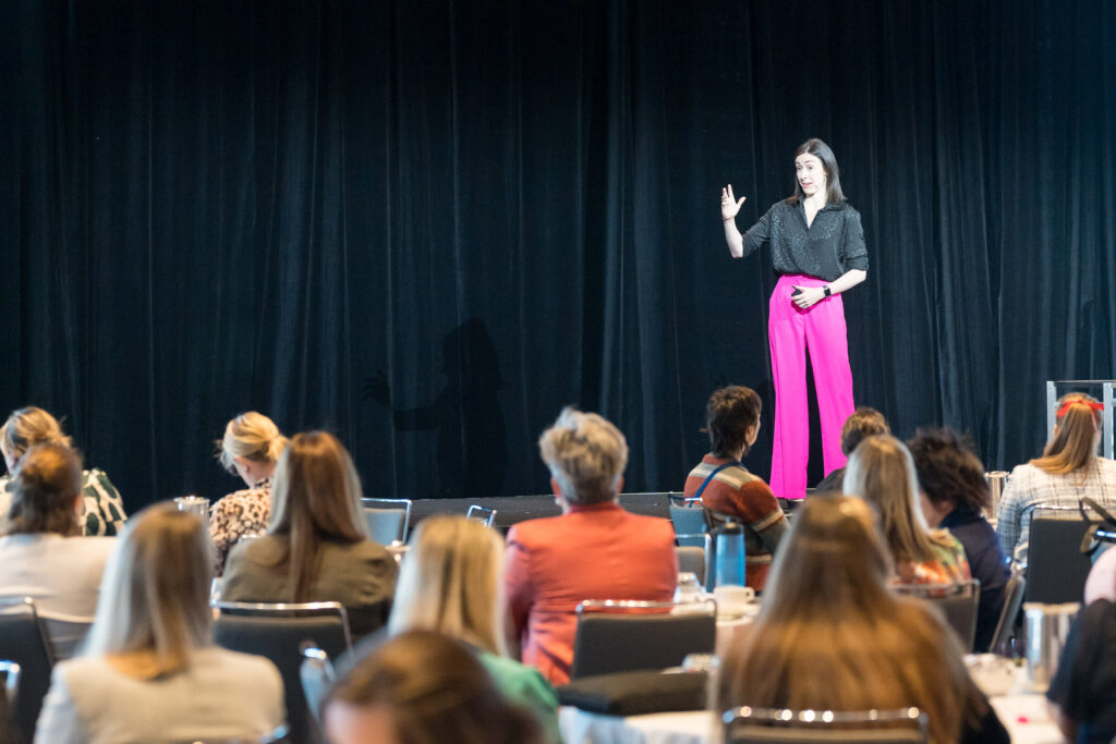 Holly Ransom speaking on stage about authentic leadership and navigating uncertainty with confidence and clarity